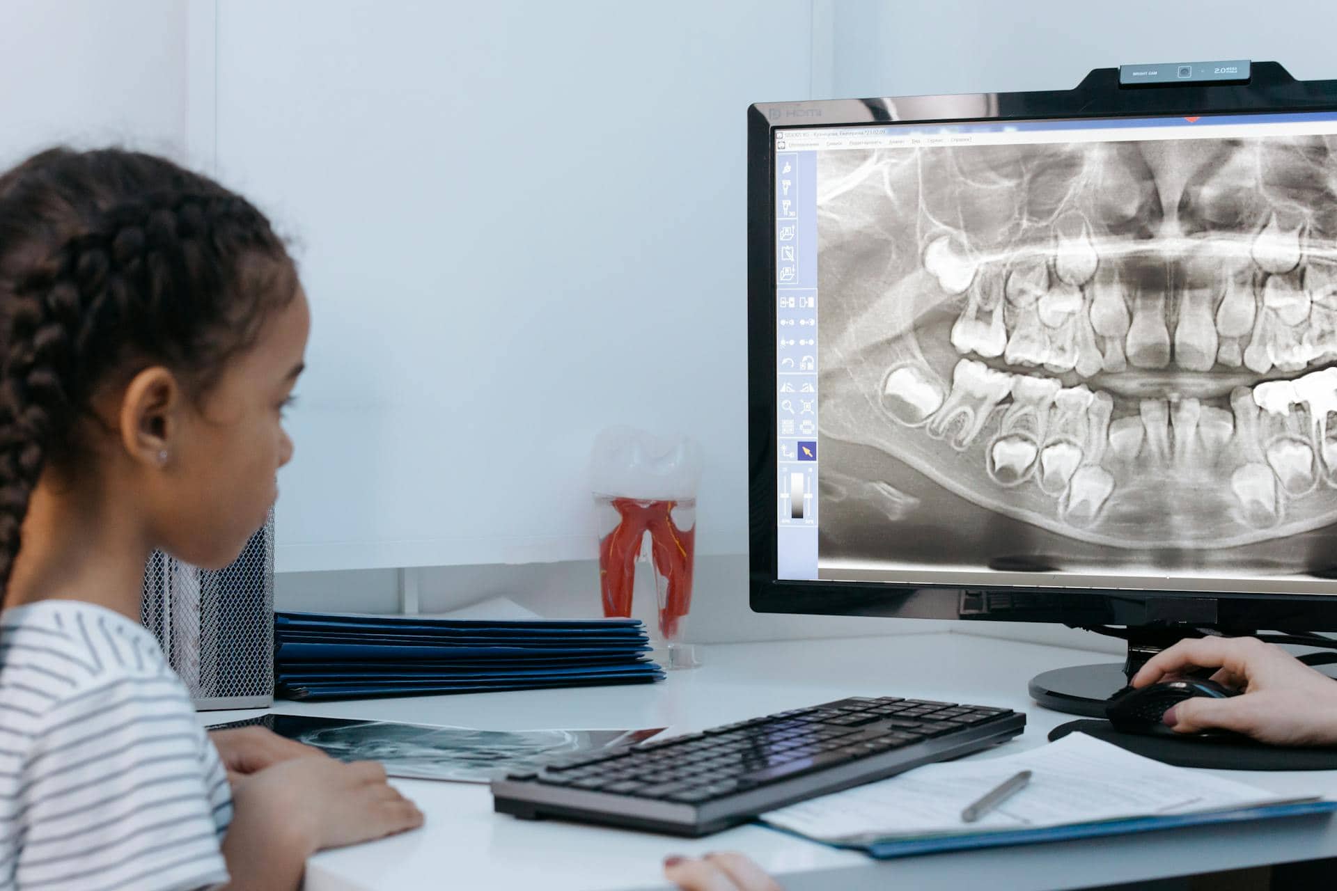 A child viewing a dental X-ray with a dentist during a consultation about bruxism in kids.