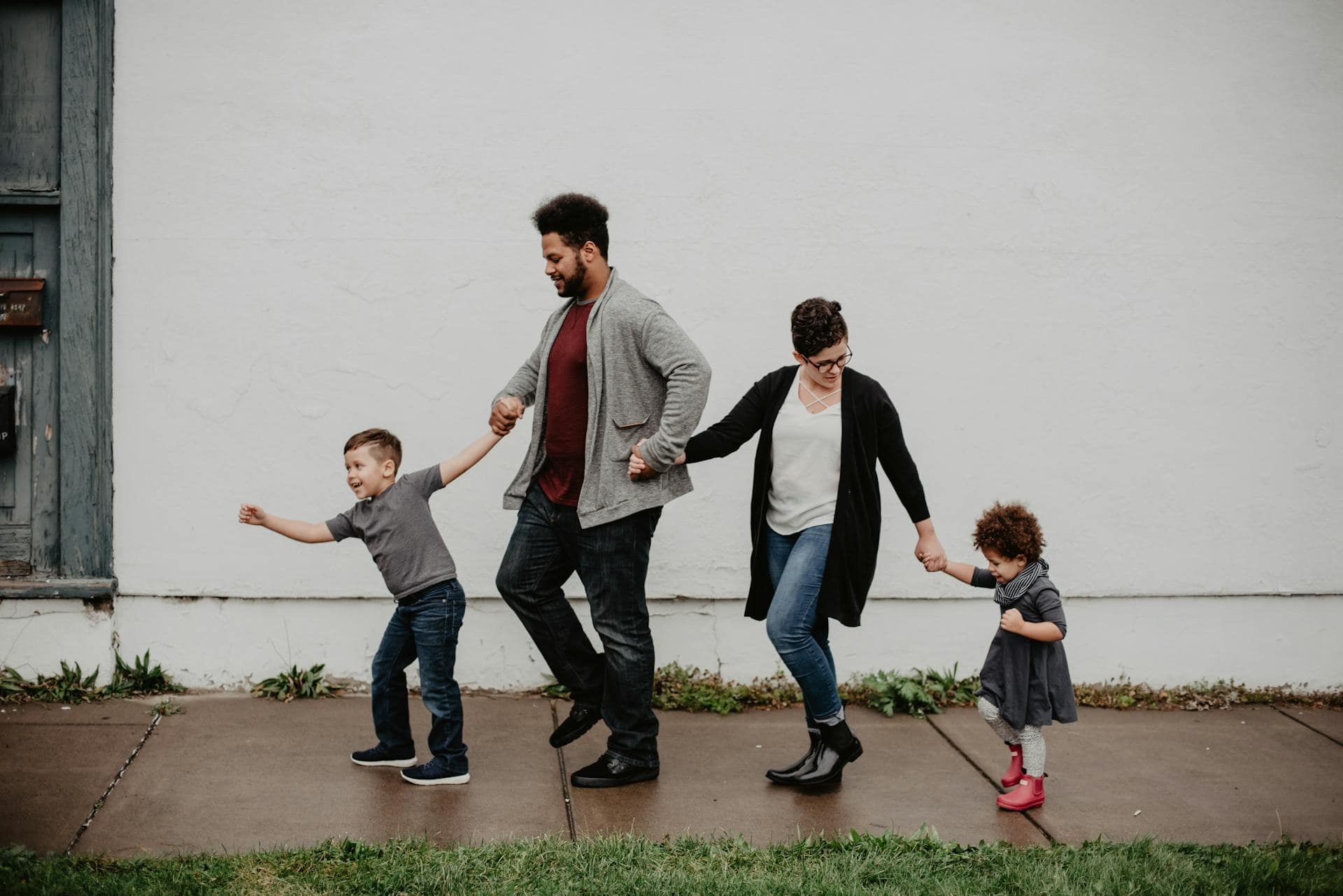 Two parents walking along a footpath with their children