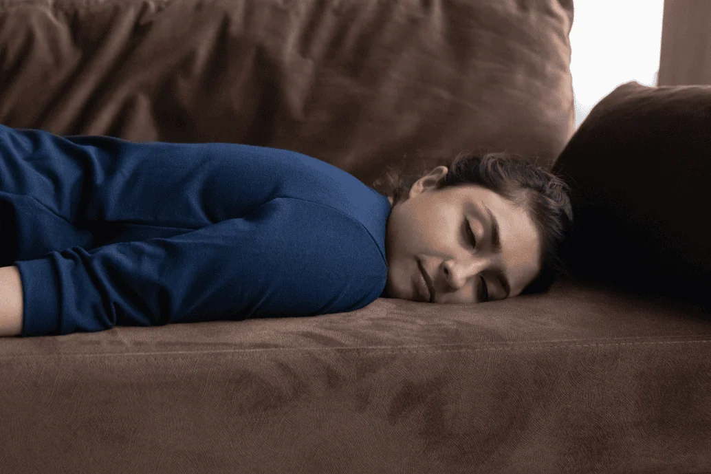 Woman lying down on the couch with her eyes closed