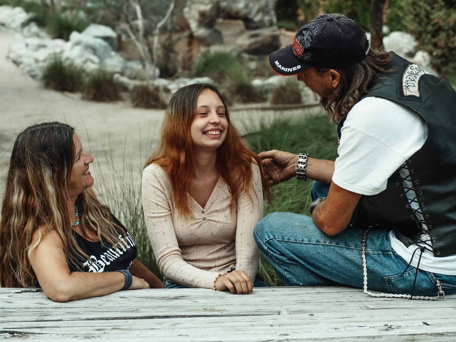Smiling teenage girl spending time outdoors with supportive parents, showing a positive family connection and emotional well-being