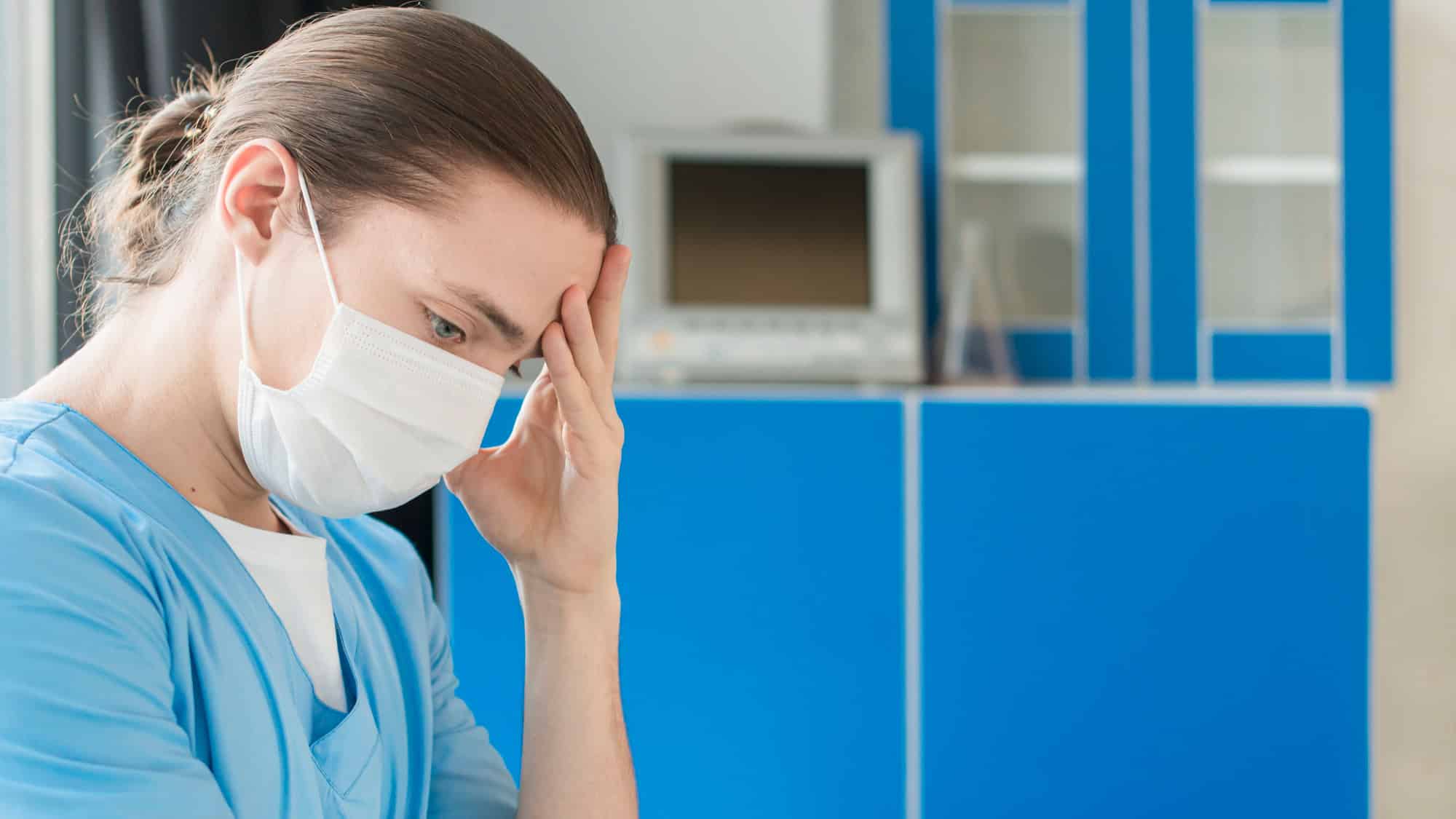 Frontline healthcare worker showing signs of stress and hypervigilance after shift, struggling to relax in a clinical environment