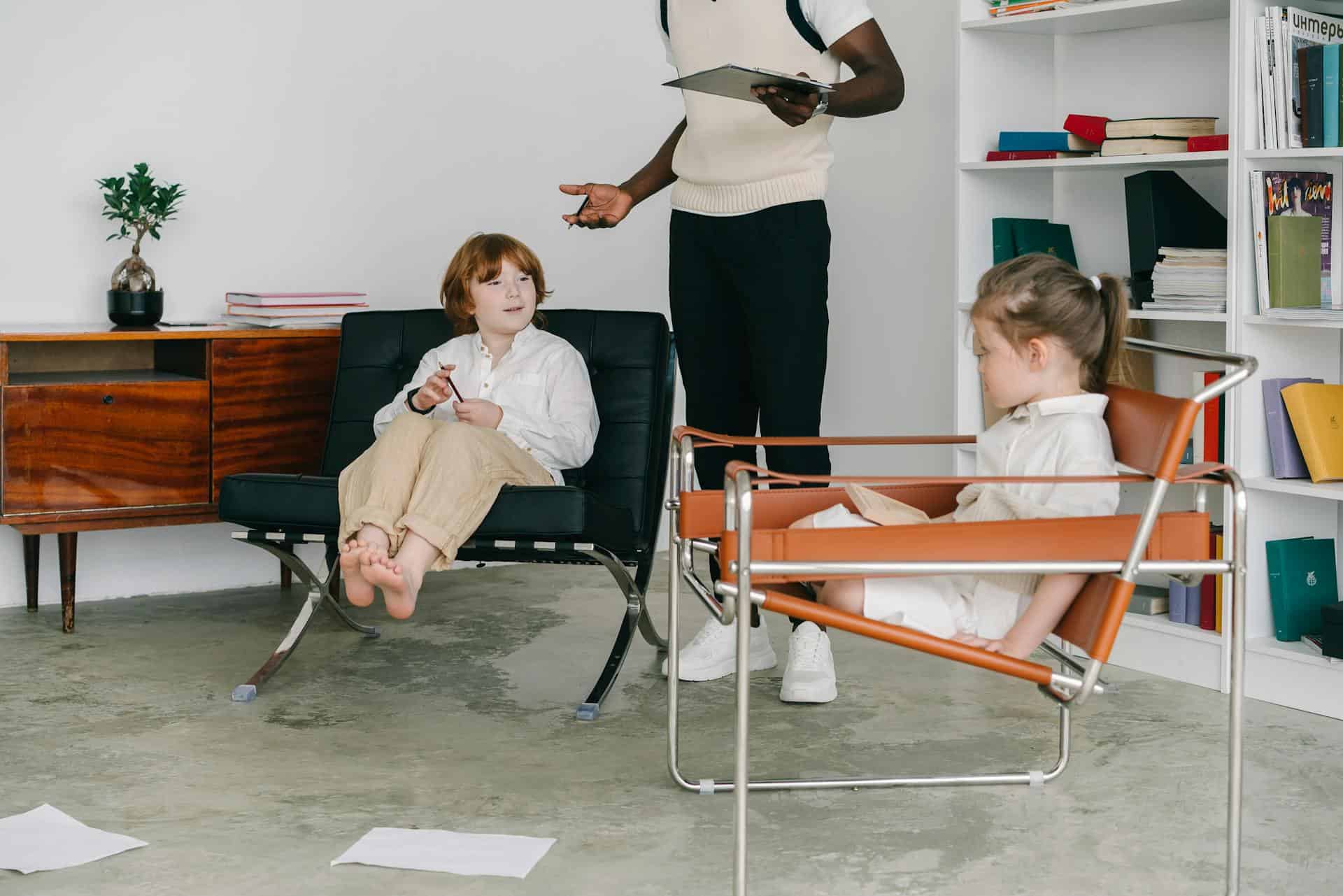 Therapist leading a Cognitive Pattern Reprogramming for ADHD kids session with two children in a modern, comfortable office setting.