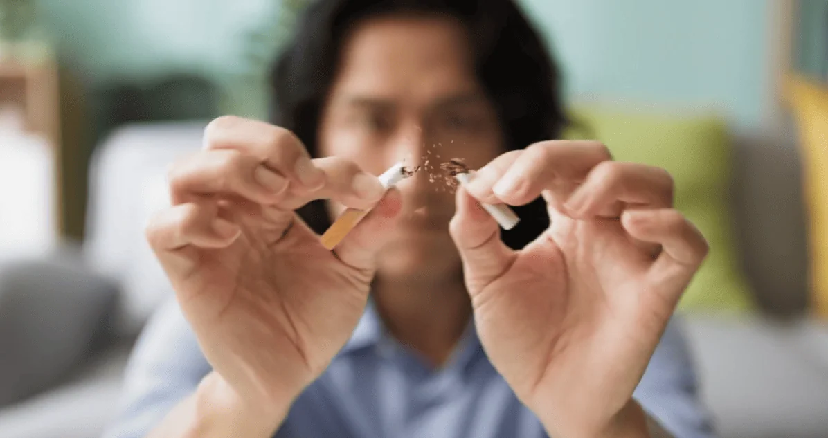 A man snapping a cigarette in half