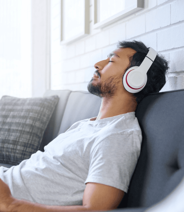 Man listening to a session with headphones on the couch