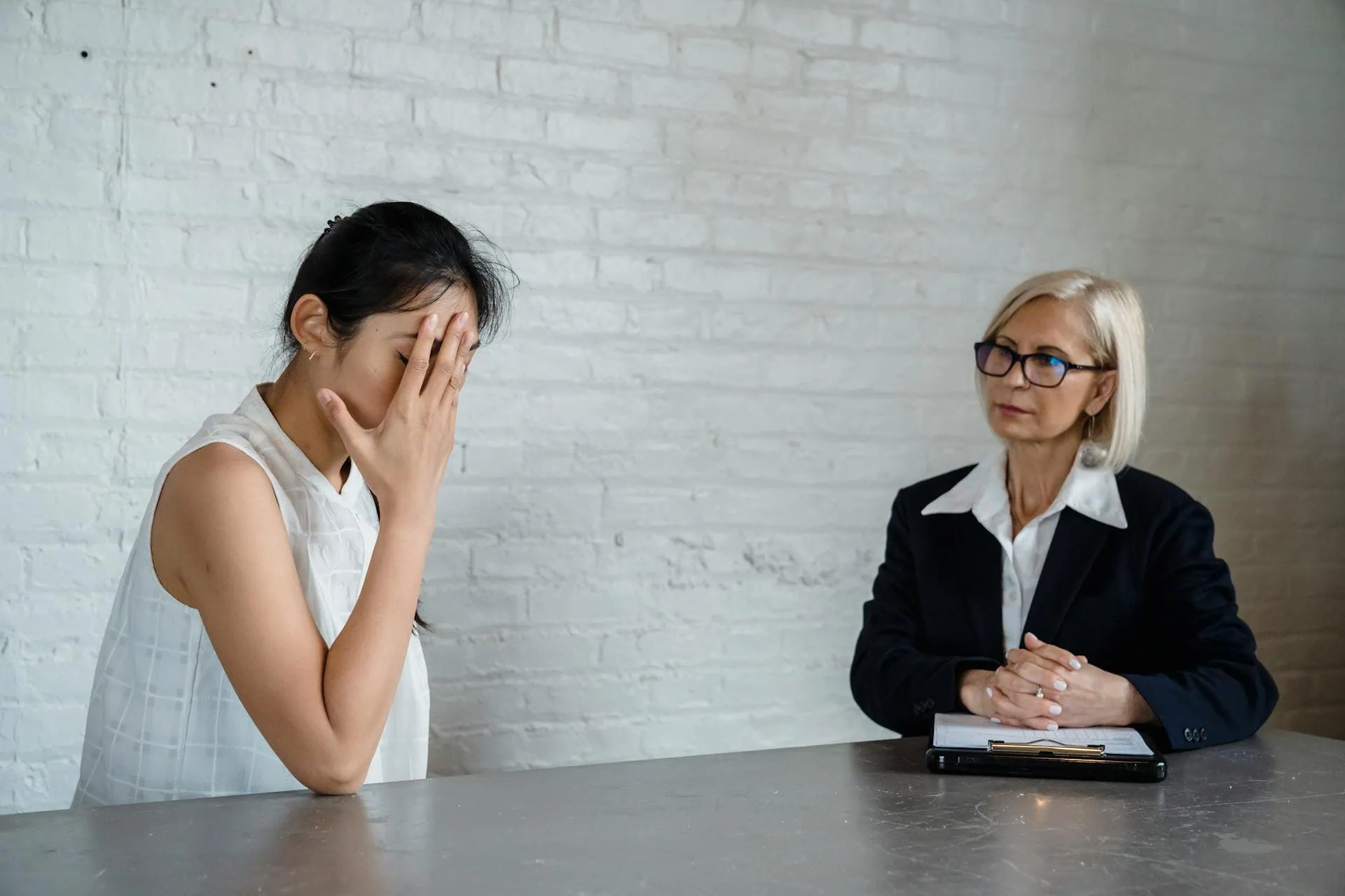Young woman stressed and covering face during therapy session with a counsellor, discussing emotional issues Sleep Insomnia Blog Post