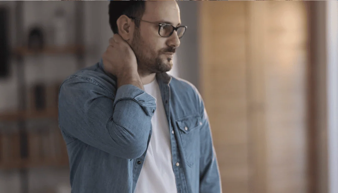 Thoughtful man touching neck
