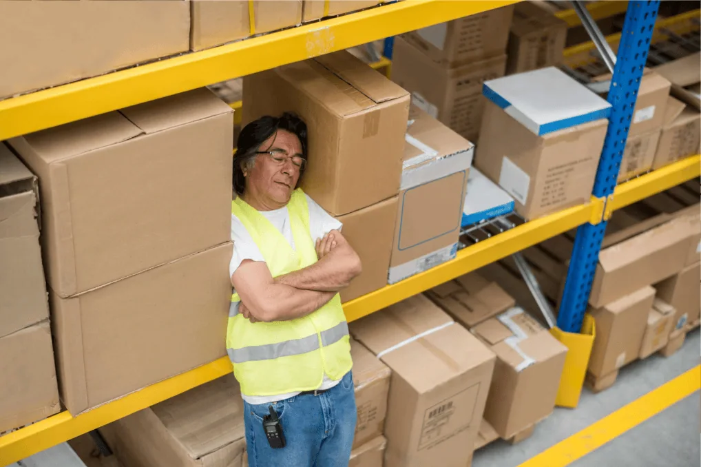 Tired warehouse worker sleeping on shift