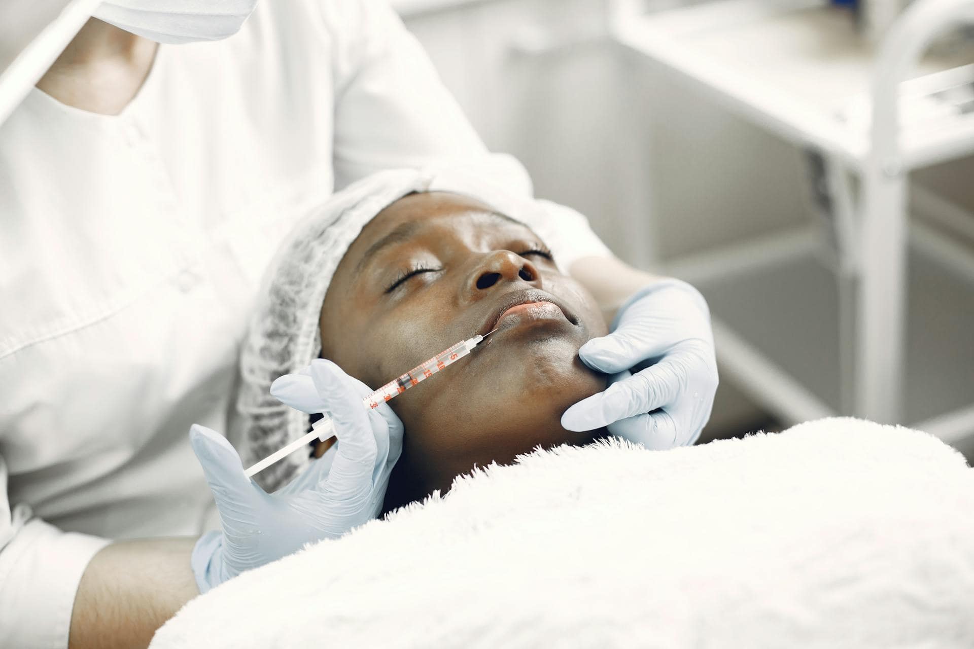 A woman receiving a Botox injection in the jaw area, a common temporary treatment for TMJ Disorder symptoms